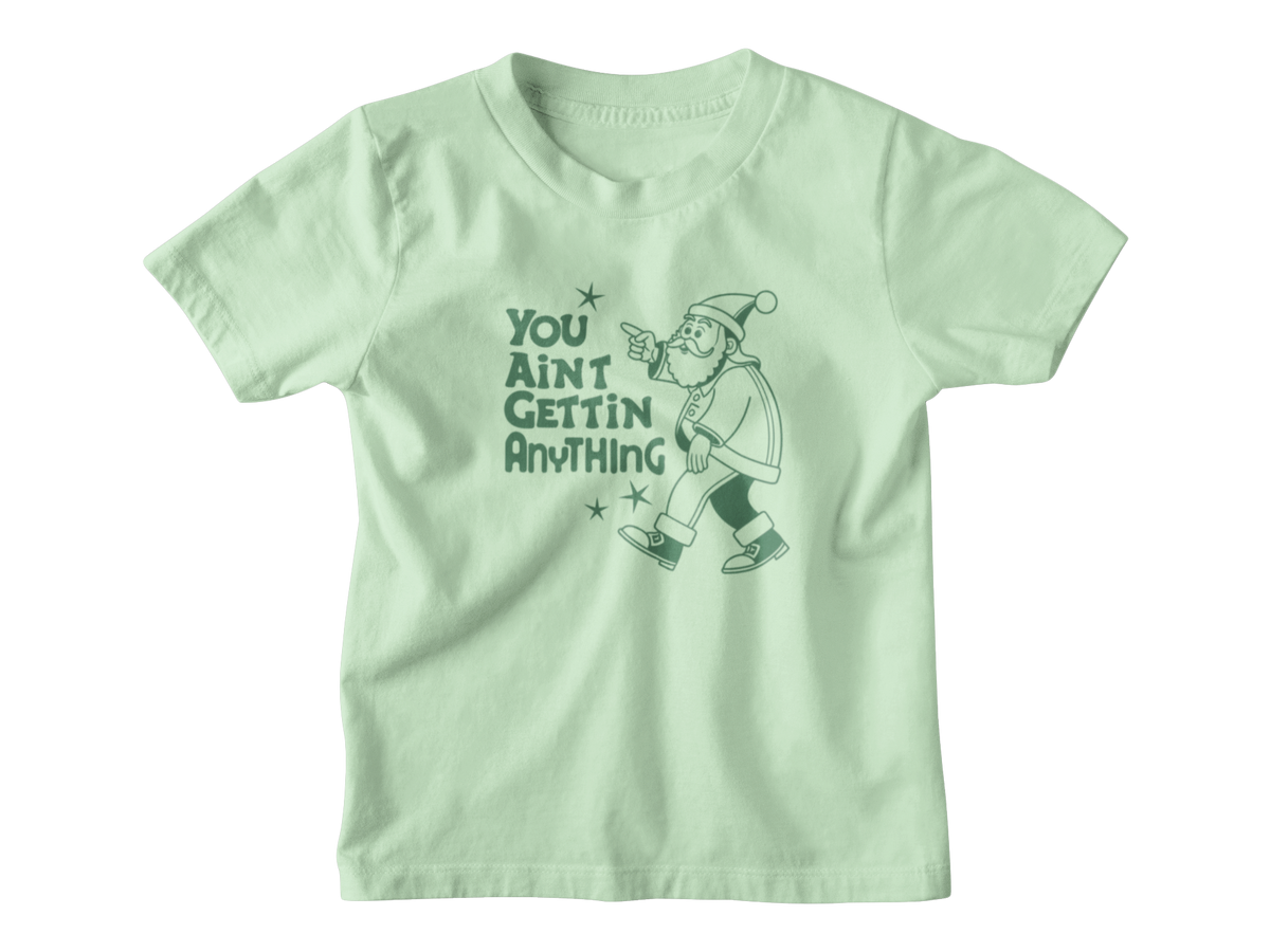 A Christmas light green kid tee with a graphic of a Santa Clause pointing and the text &