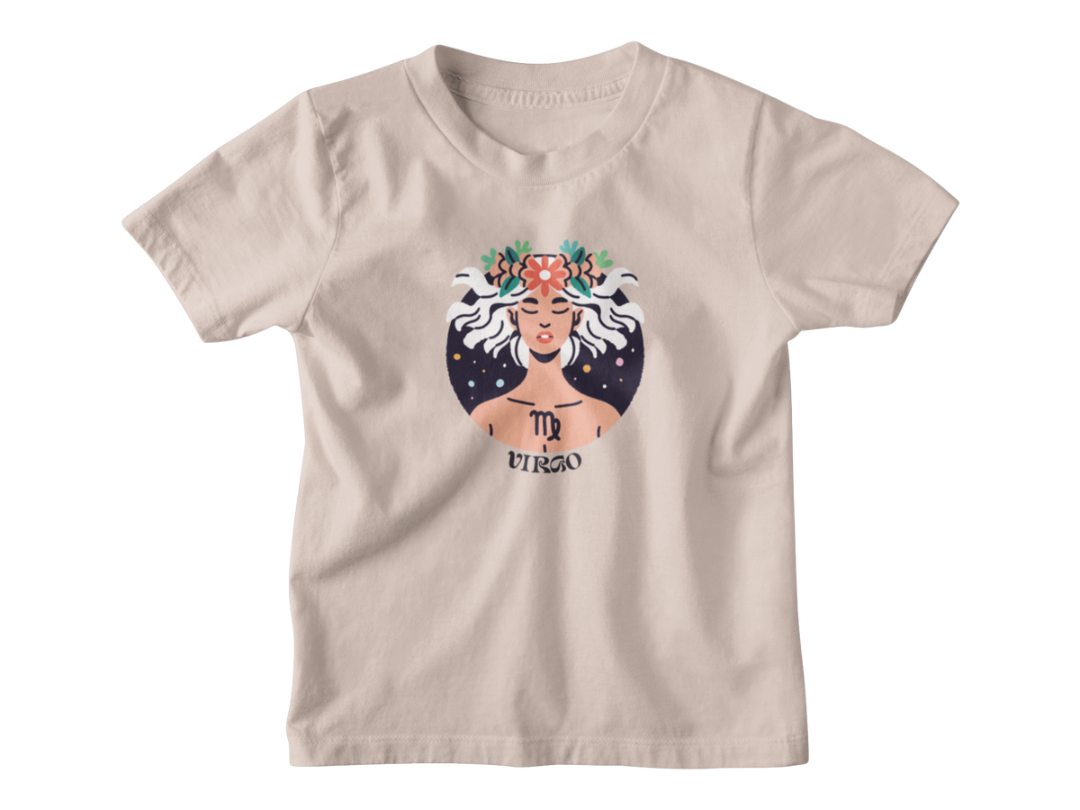 A tan short-sleeve kids t-shirt with a graphic of the Virgo zodiac sign, featuring an illustrated figure with white hair, a floral crown, and a starry background.