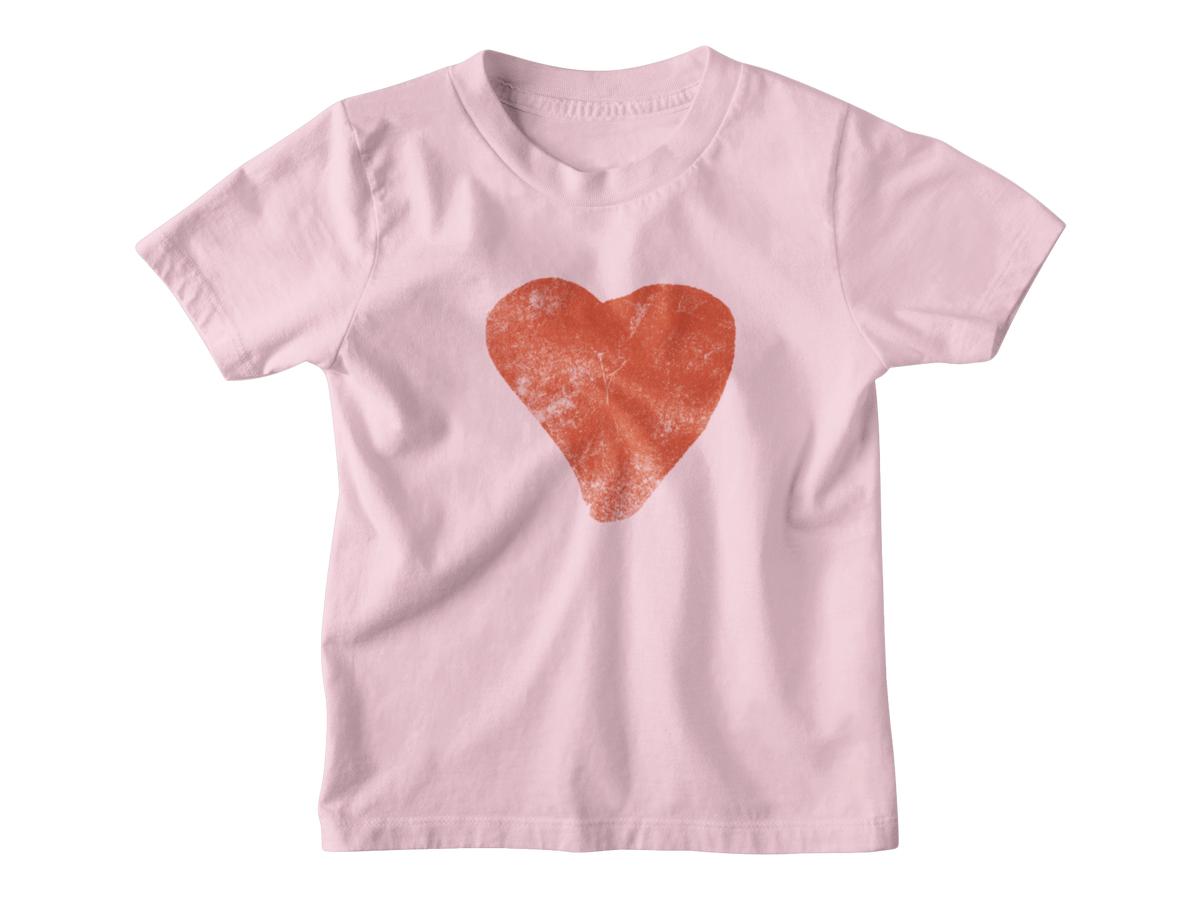 A light pink short-sleeve kids tee featuring a textured red heart graphic printed on the center chest, meant for Valentine&