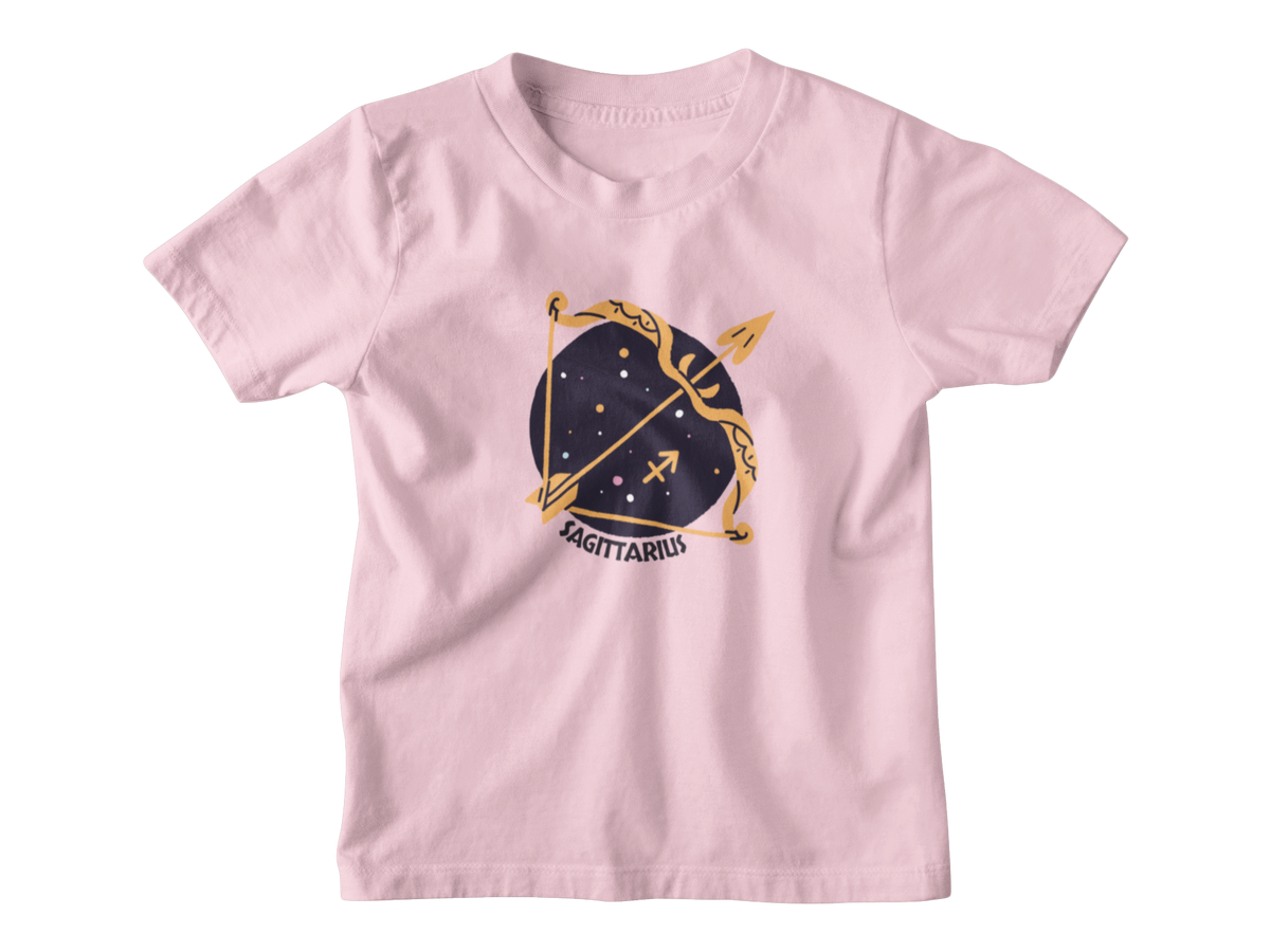 A pink short-sleeve kids t-shirt featuring a Sagittarius zodiac golden bow and arrow set against a dark navy blue starry circle, with the word &