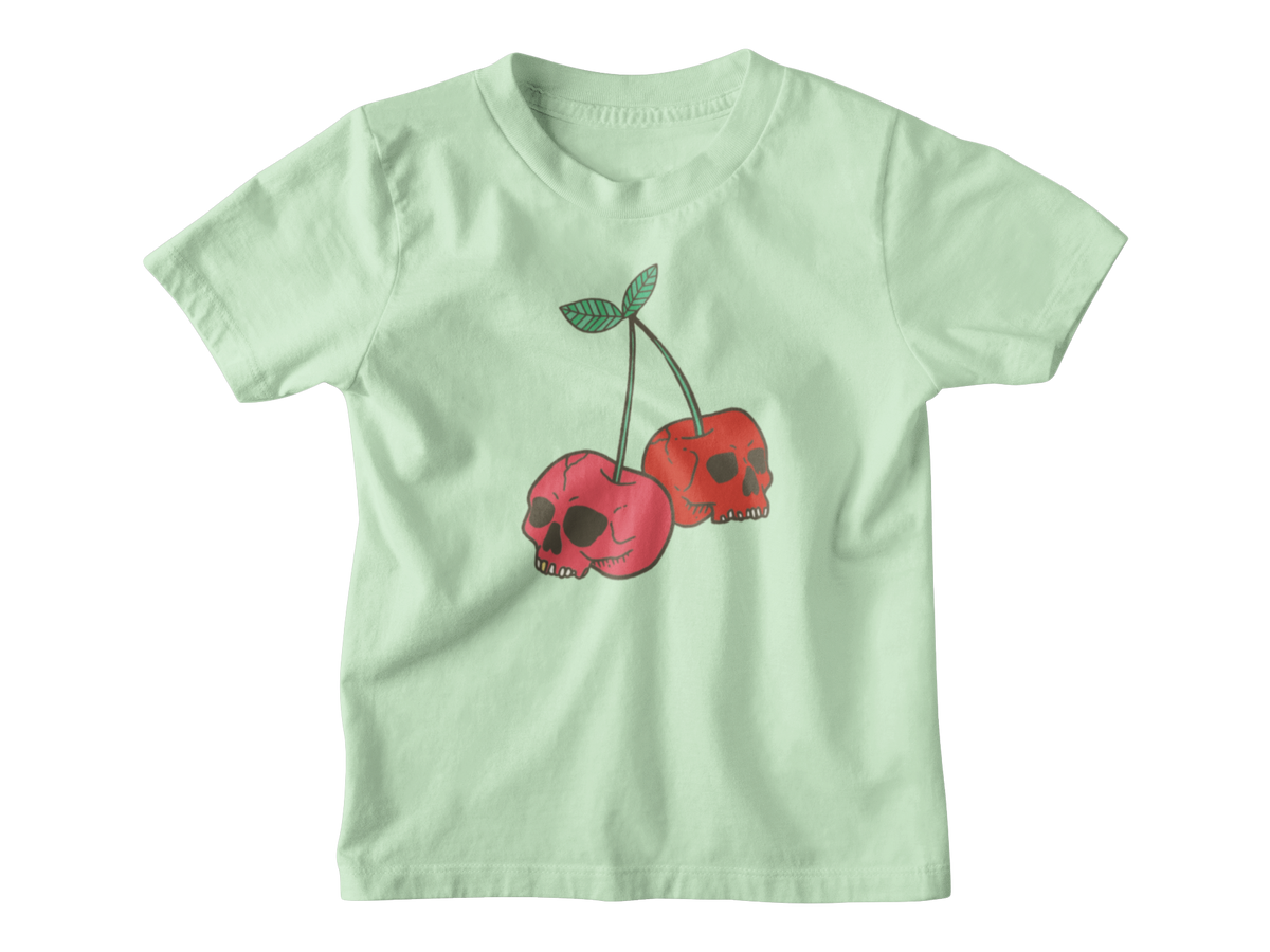 A mint short-sleeve kids t-shirt featuring a graphic of two red cherries with skull faces and green stems, displayed on a clean white background.