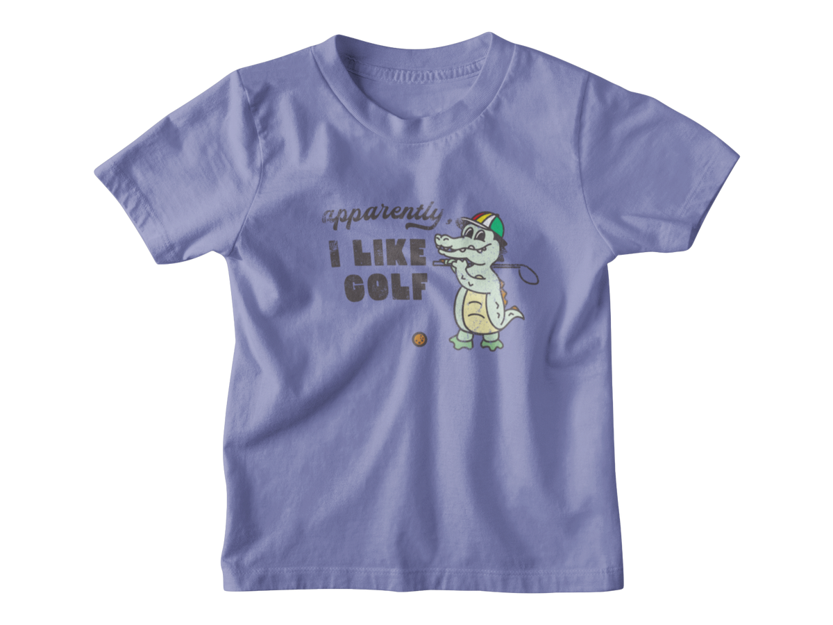 A light purple short-sleeve t-shirt with a cartoon graphic of a crocodile playing golf, accompanied by the text &