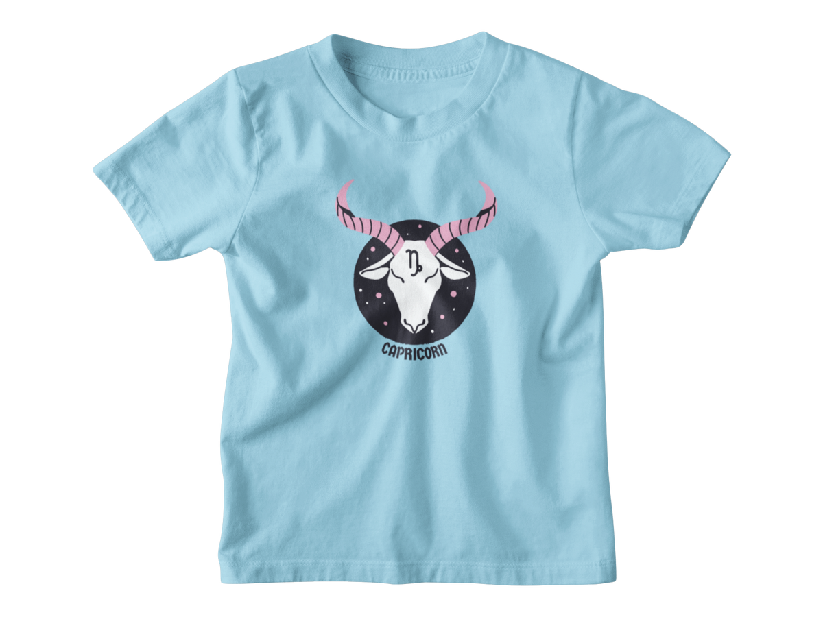 A light blue short-sleeve t-shirt with a central graphic of a Capricorn zodiac symbol featuring a white goat head with pink horns inside a black circle, on a plain white background.