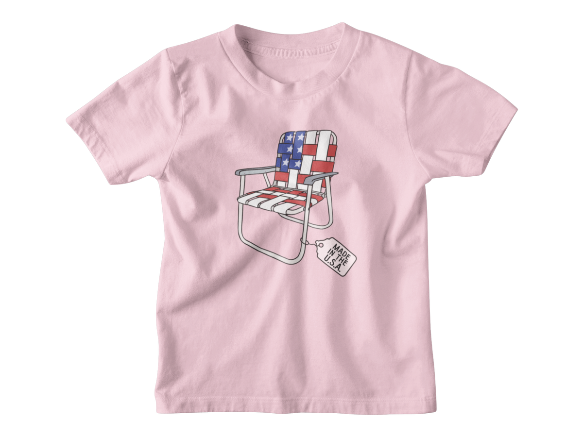 A pink short-sleeve kids t-shirt for 4th of July with a folding lawn chair featuring an American flag pattern, with a &