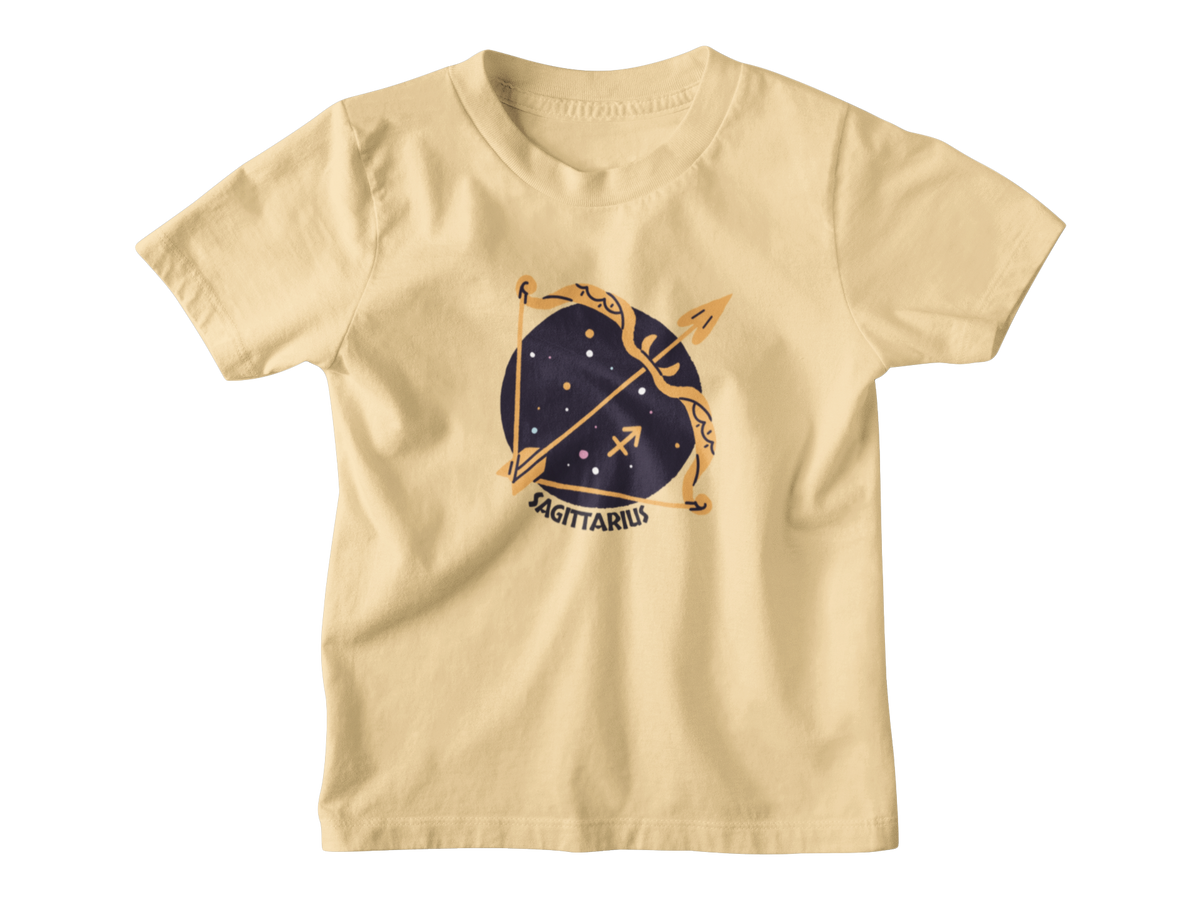 A light yellow short-sleeve kids t-shirt featuring a Sagittarius zodiac golden bow and arrow set against a dark navy blue starry circle, with the word &