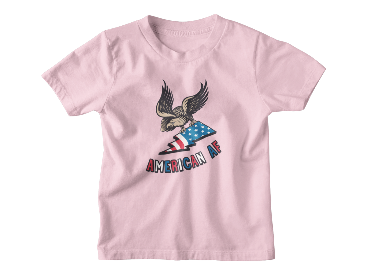 A light pink short-sleeve t-shirt with a graphic of an eagle holding an American flag and the text &