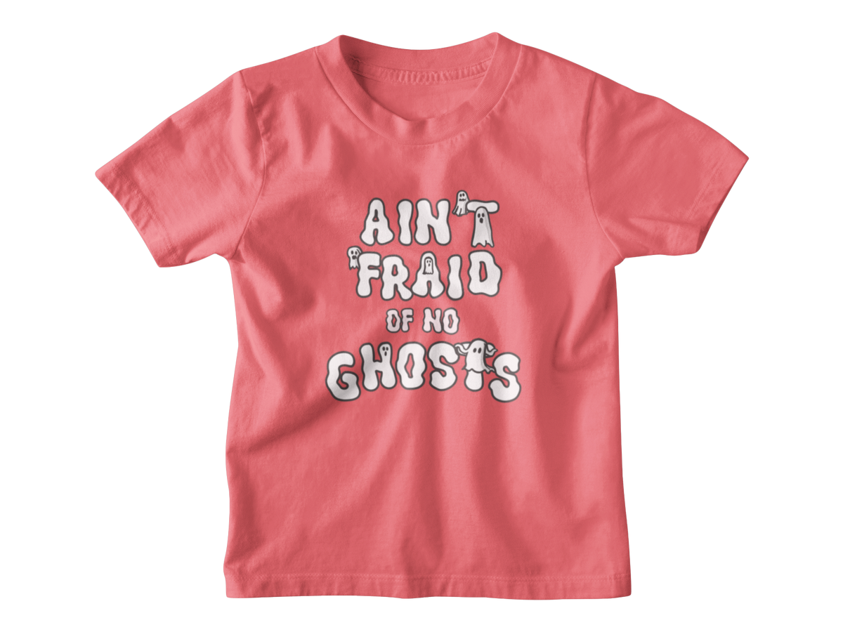An orangey pink short-sleeve kid t-shirt with a white graphic Halloween text print that reads &