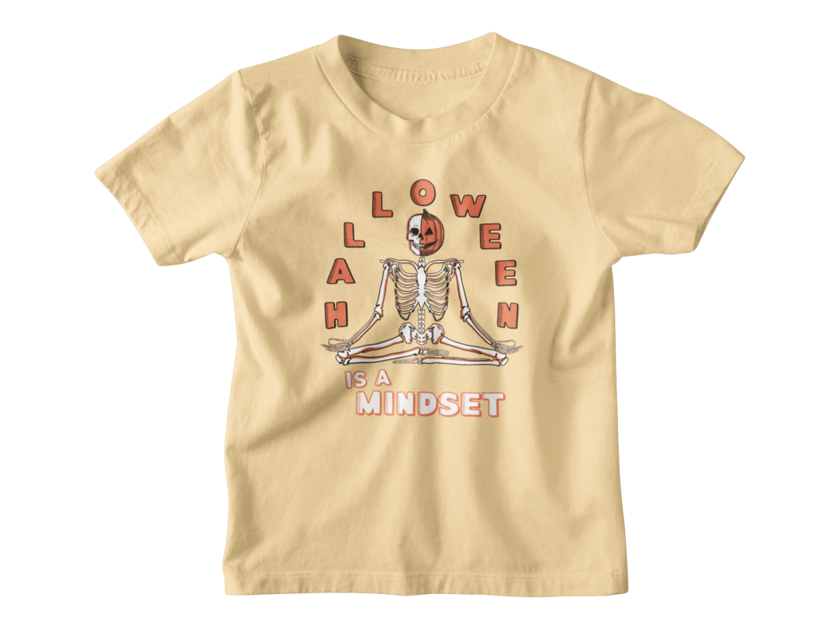 A yellow short-sleeve kids Halloween t-shirt with a graphic on the front showing a skeleton meditating inside a jack-o&