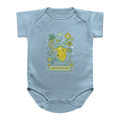 A light blue short-sleeve infant onesie featuring a Capricorn astrology goat surrounded by tarot flowers, with the word &