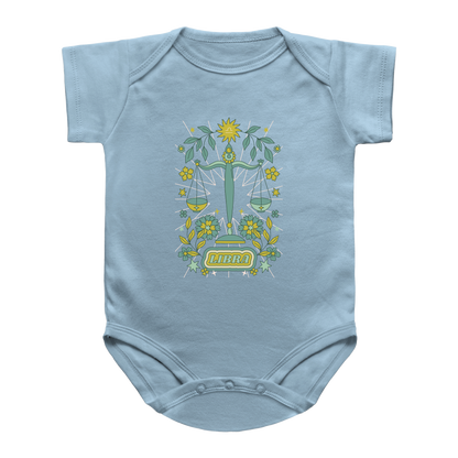 A light blue infant onesie featuring a tarot graphic of a green scale of justice Libra surrounded by yellow flowers and green leaves, with the word &