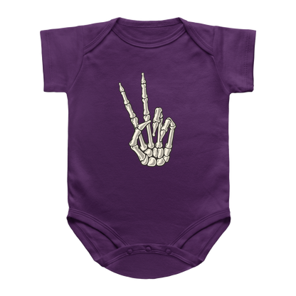 A purple short-sleeve infant onesie featuring a graphic of a skeletal hand making the peace gesture on the chest, for Halloween holiday.