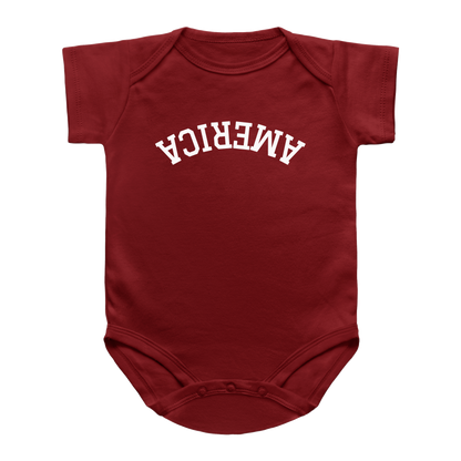 A short-sleeve baby bodysuit for 4th of July in dark red with the word &