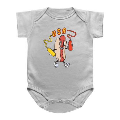 A 4th of July white short-sleeve infant onesie featuring a hot dog holding a yellow mustard bottle and a red ketchup bottle, with the word &