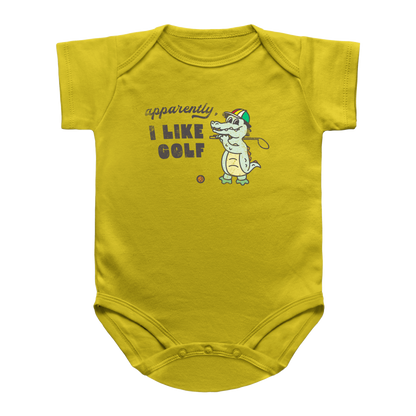 A yellow short-sleeve baby infant bodysuit with a cartoon alligator wearing a green and red golf hat, holding a golf club, next to the text &