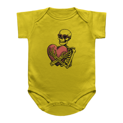 A yellow infant onesie featuring a graphic print of a Halloween skeleton wearing heart sunglasses and hugging a red heart.
